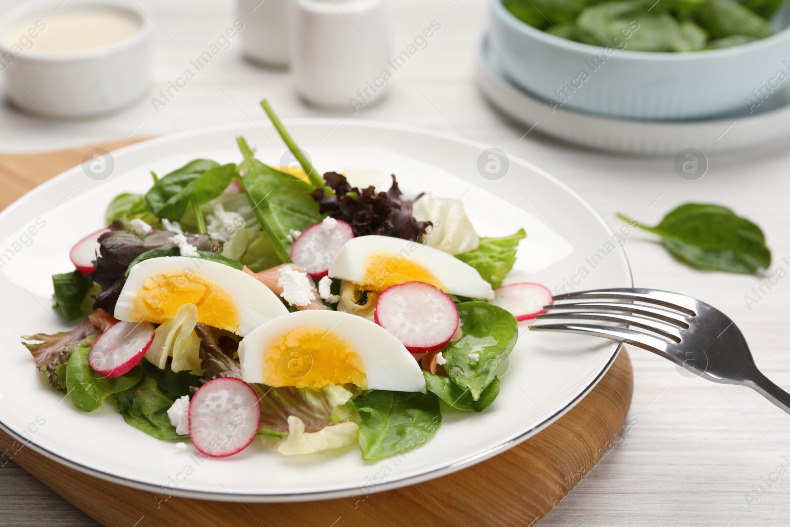 Photo of Delicious salad with boiled egg, radish and cheese on white wooden table, closeup