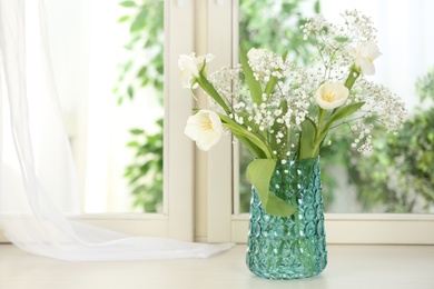 Photo of Beautiful fresh flowers on window sill indoors. Space for text