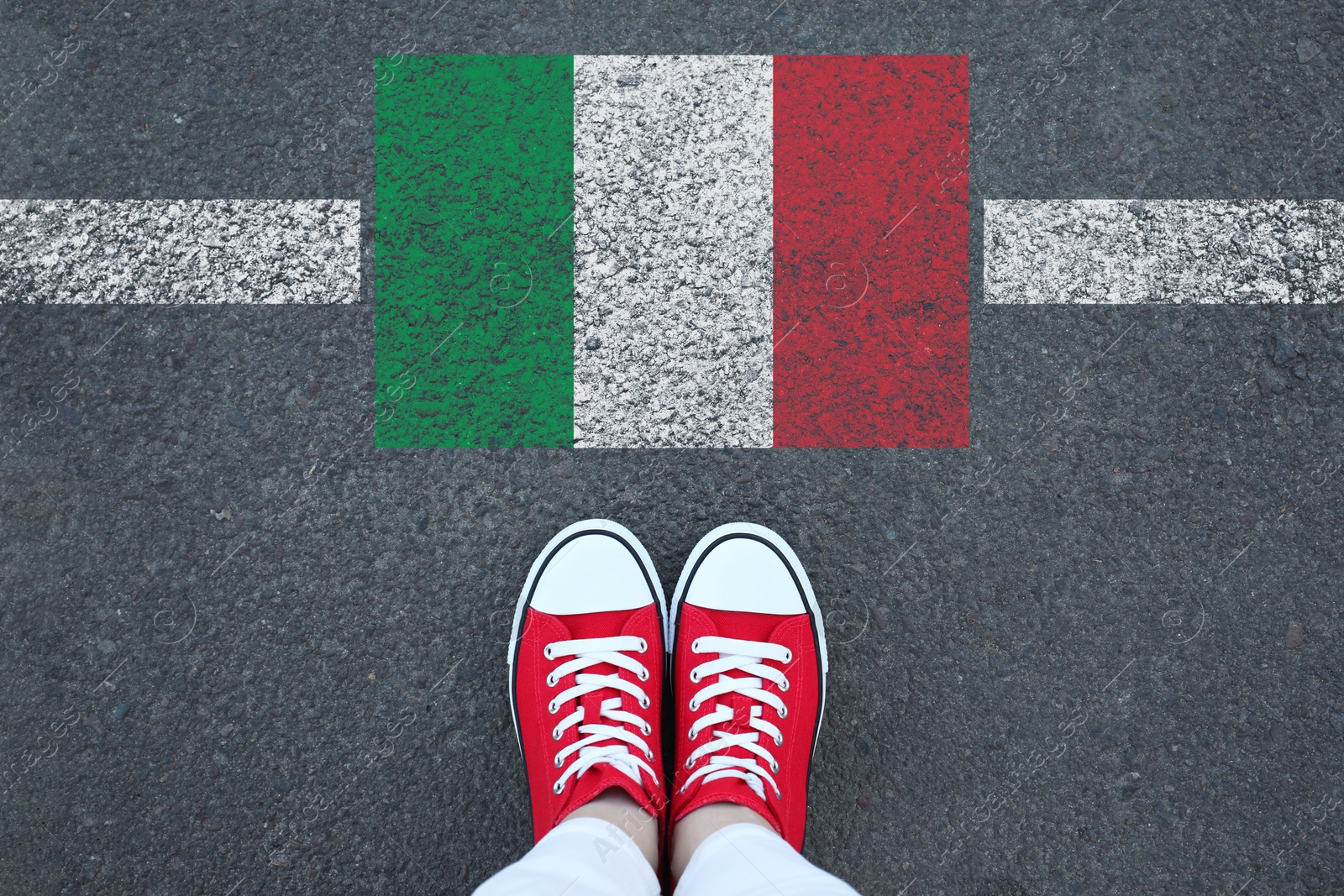 Image of Immigration. Woman standing on asphalt near flag of Italy, top view