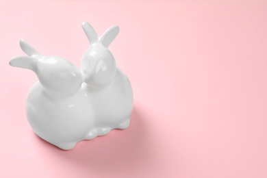 Ceramic Easter bunnies on color background, space for text