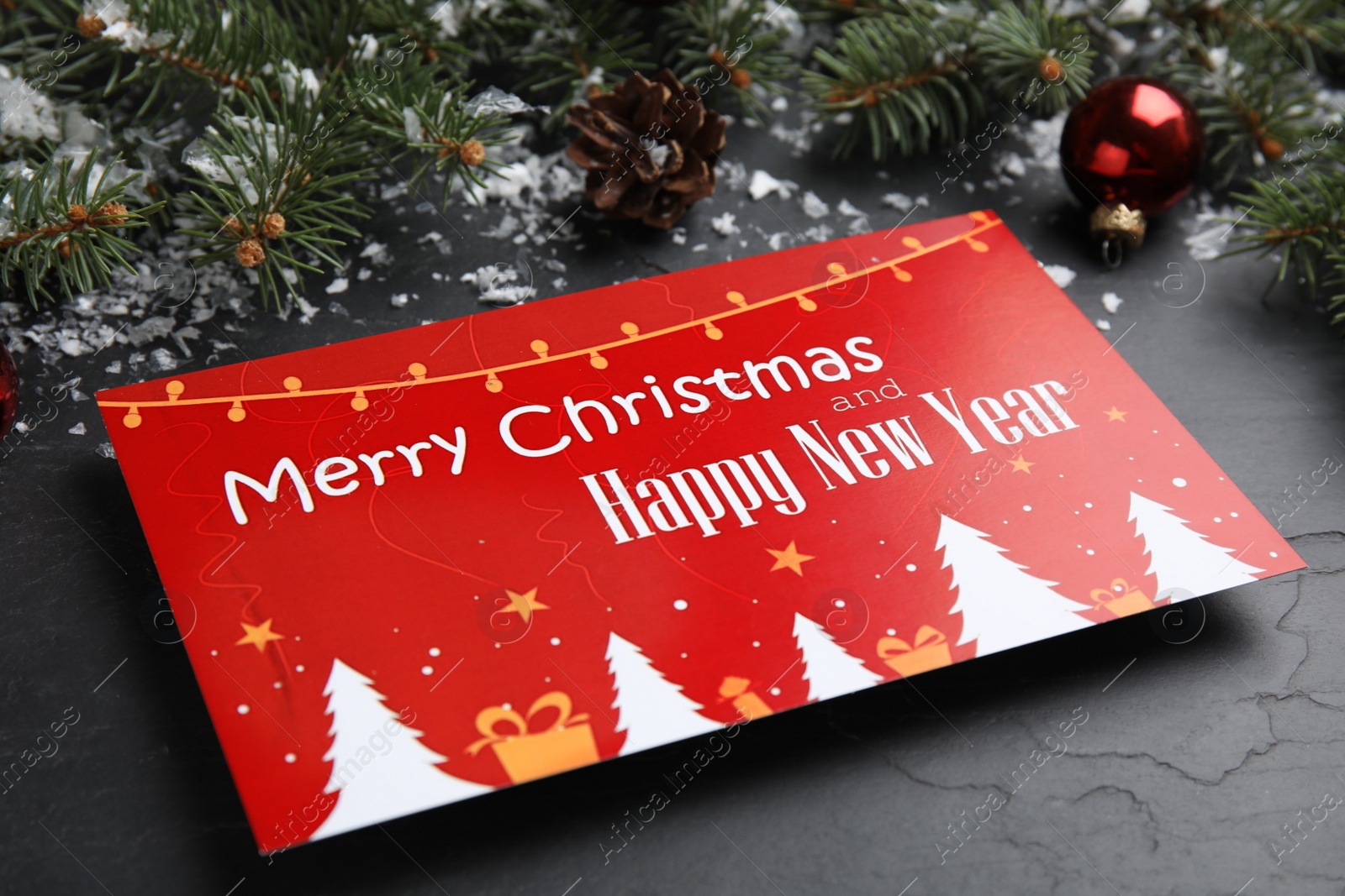 Photo of Greeting card and Christmas decor on black background, closeup