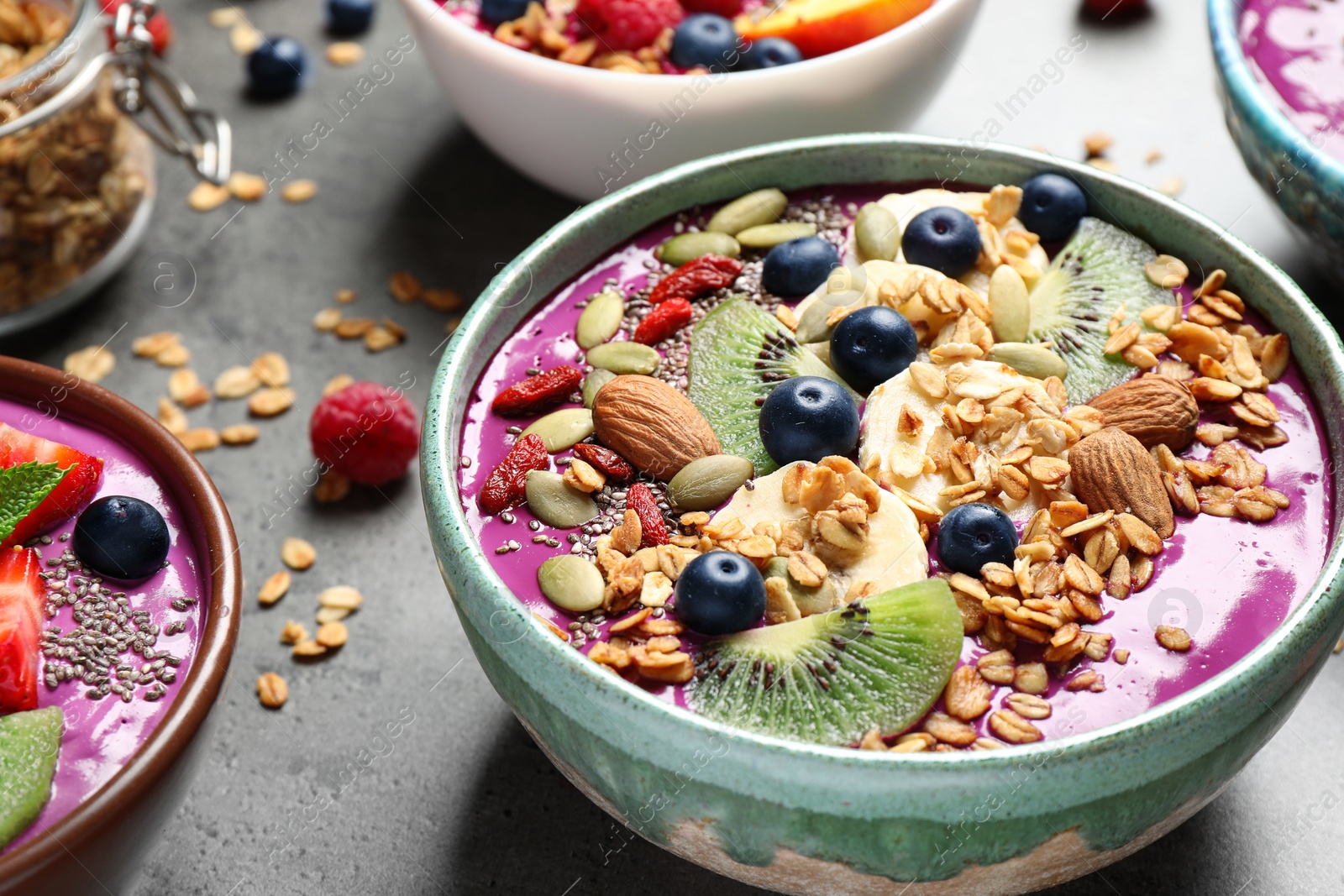 Image of Delicious acai smoothie with toppings in bowls on table