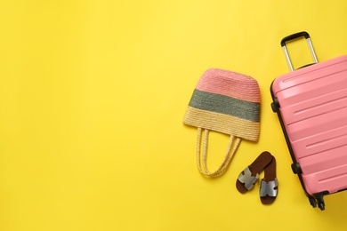 Photo of Stylish suitcase, beach bag and shoes on color background, top view. Space for text