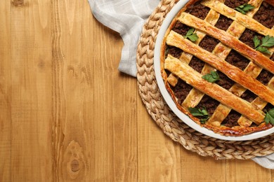 Freshly baked meat pie on wooden table, top view. Space for text