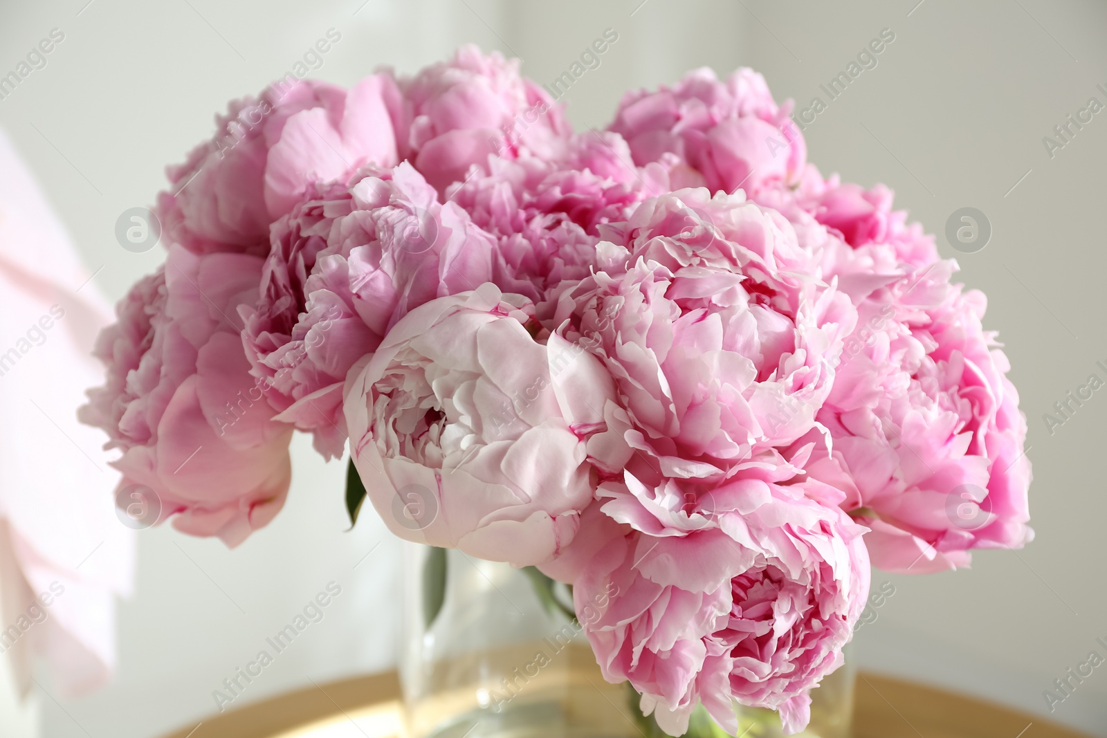 Photo of Bouquet of beautiful peonies on table indoors, closeup