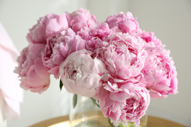 Bouquet of beautiful peonies on table indoors, closeup