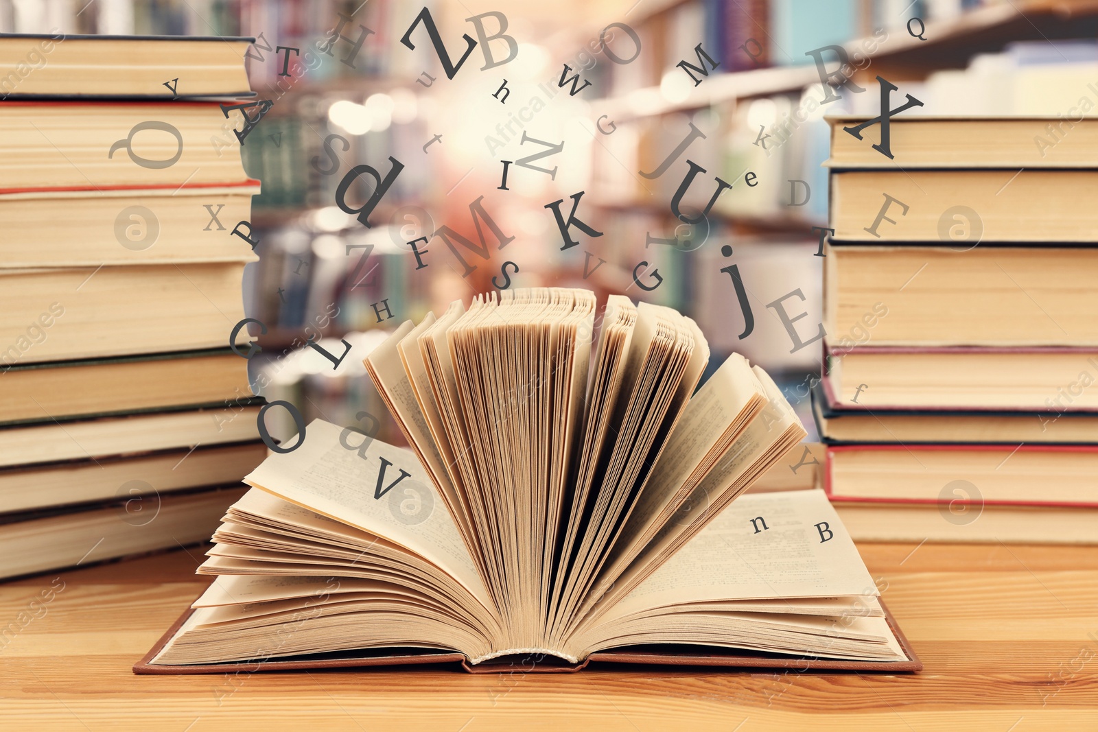 Image of Open book with letters flying out of it in library