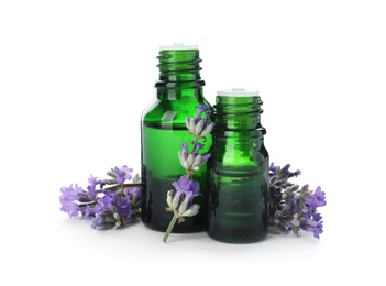 Photo of Bottles with natural lavender oil and flowers on white background