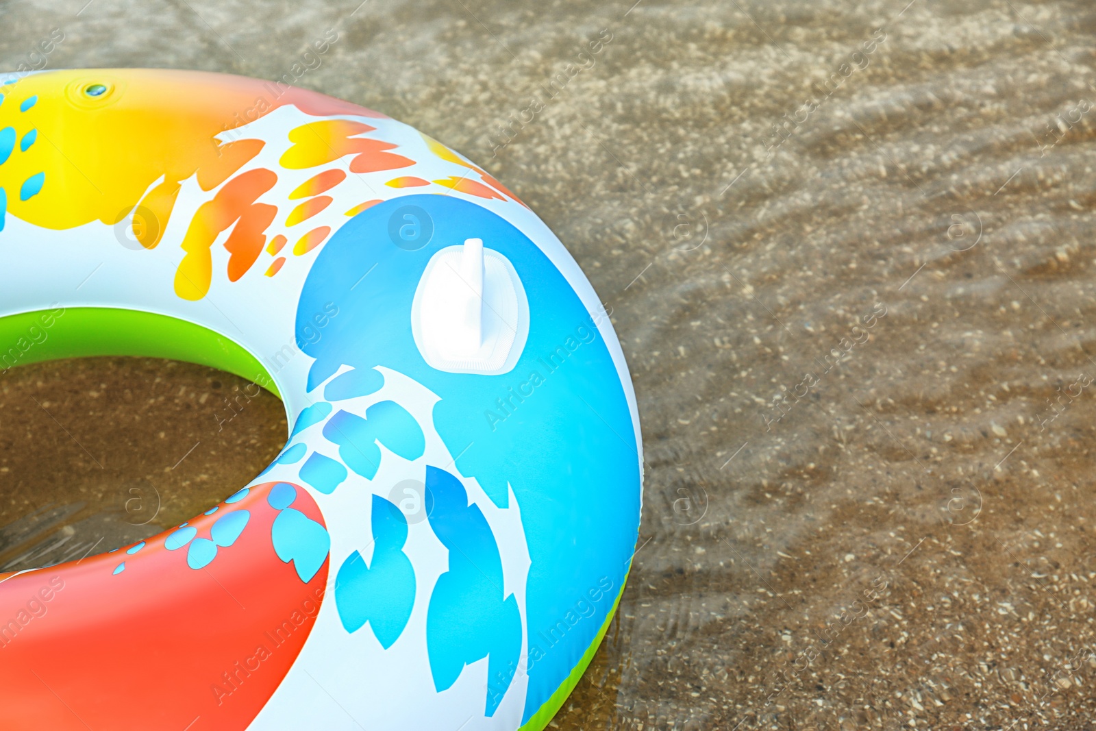 Photo of Bright inflatable ring floating on sea water. Space for text