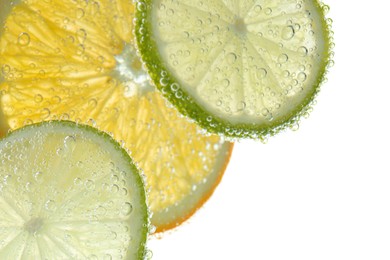 Photo of Slices of citrus fruits in sparkling water on white background, closeup