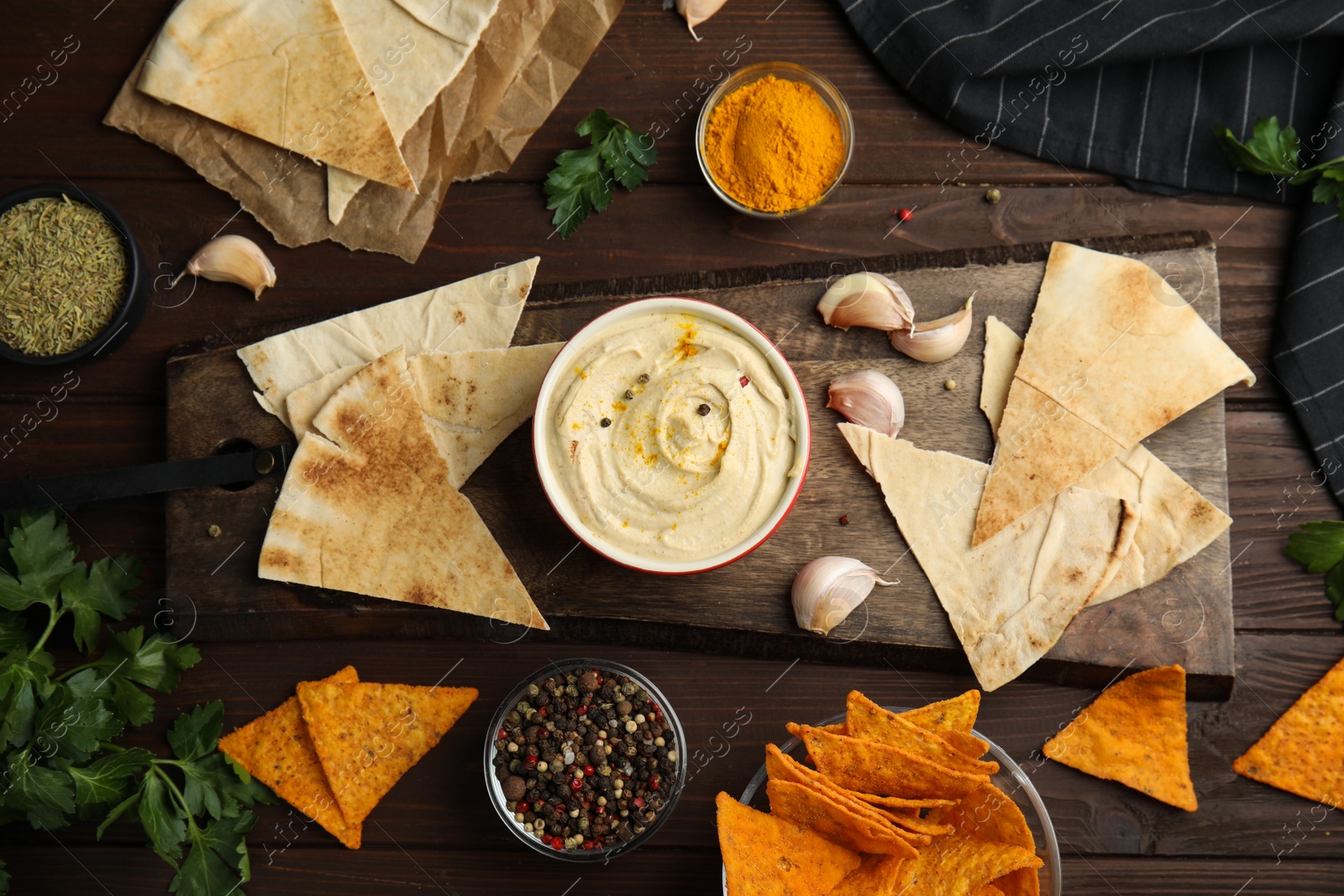 Photo of Flat lay composition with delicious hummus and pita chips on wooden table
