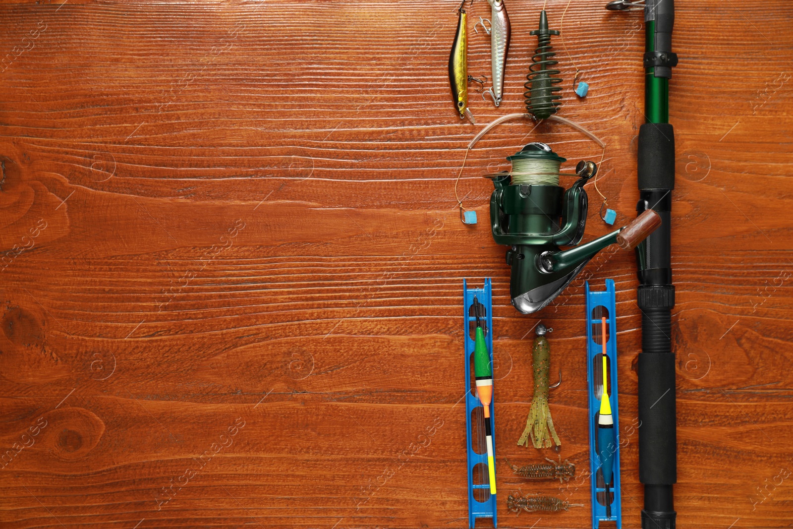 Photo of Fishing tackle on wooden table, flat lay. Space for text