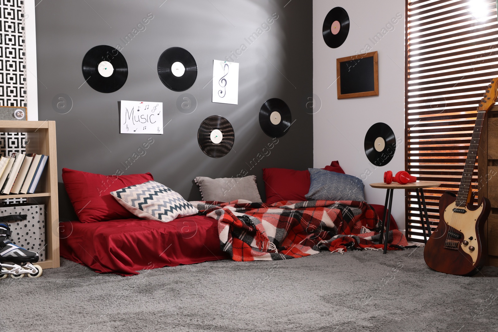 Photo of Stylish teenager's room with bed, guitar and vinyl records on wall. Interior design