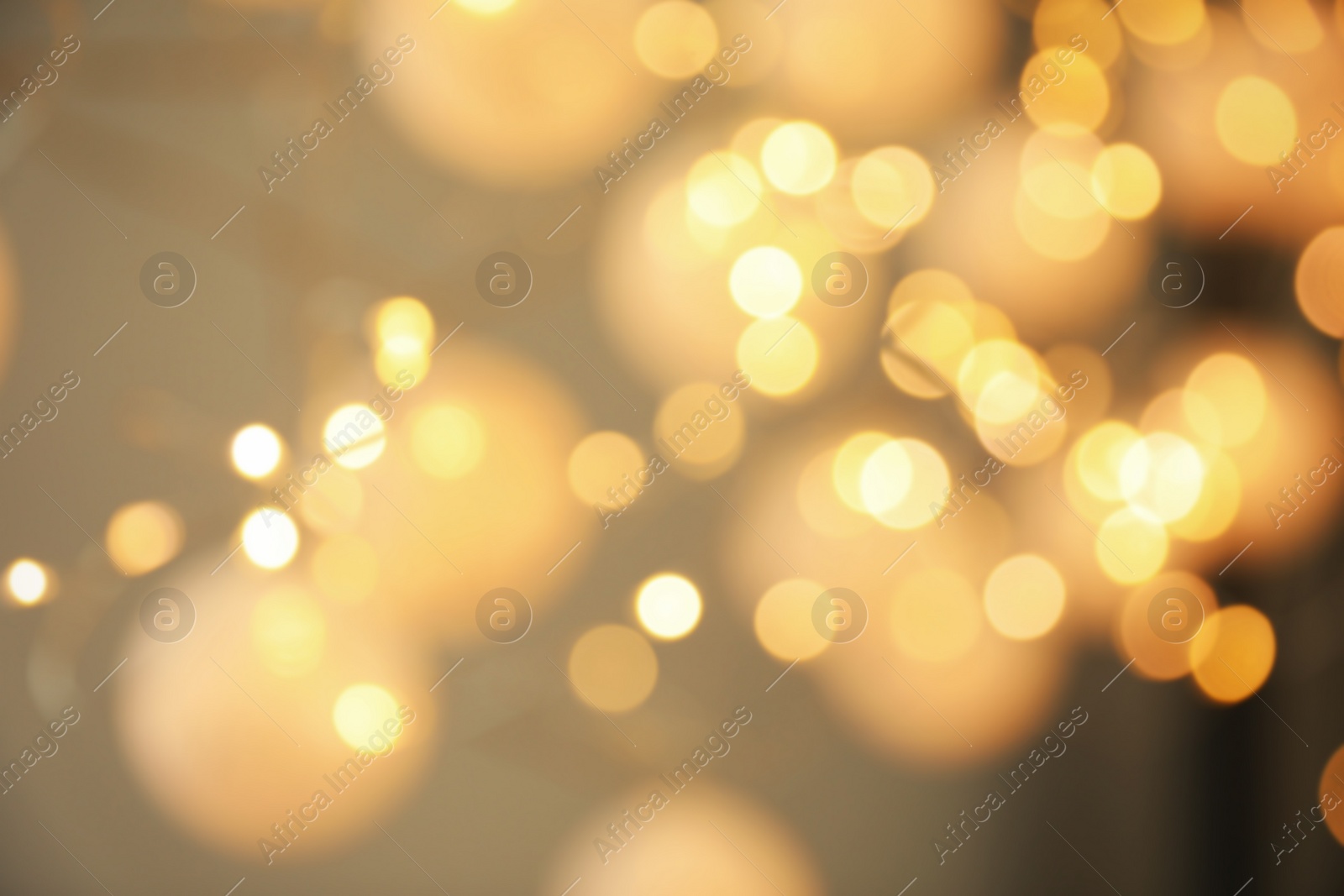 Photo of Blurred view of gold lights on dark background. Bokeh effect