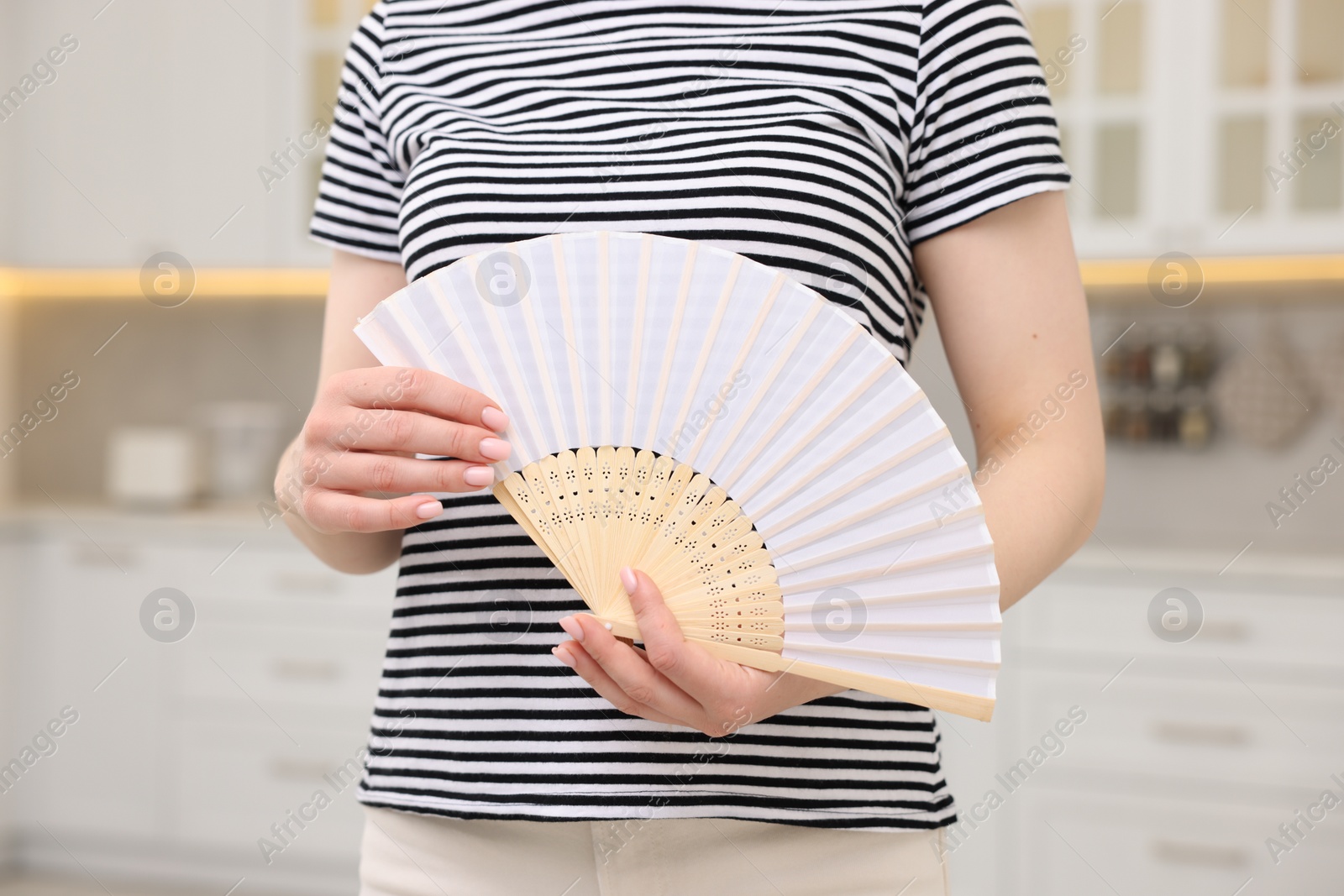 Photo of Woman with hand fan indoors, closeup view