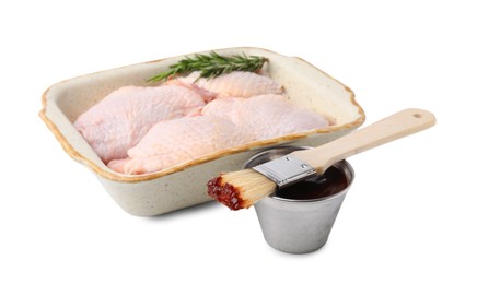 Photo of Marinade, basting brush, raw chicken and rosemary isolated on white