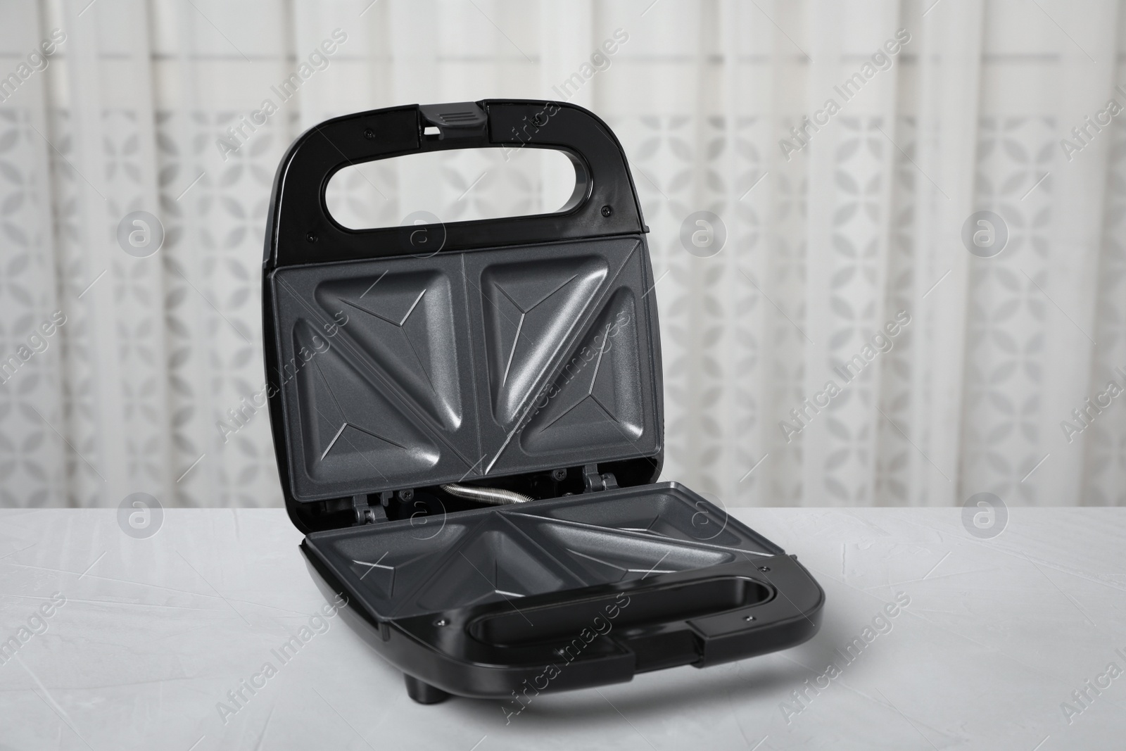 Photo of Open modern sandwich maker on light grey table