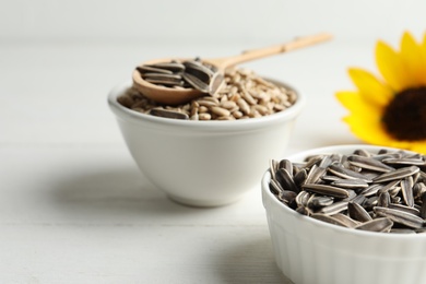 Organic sunflower seeds on white wooden table, closeup