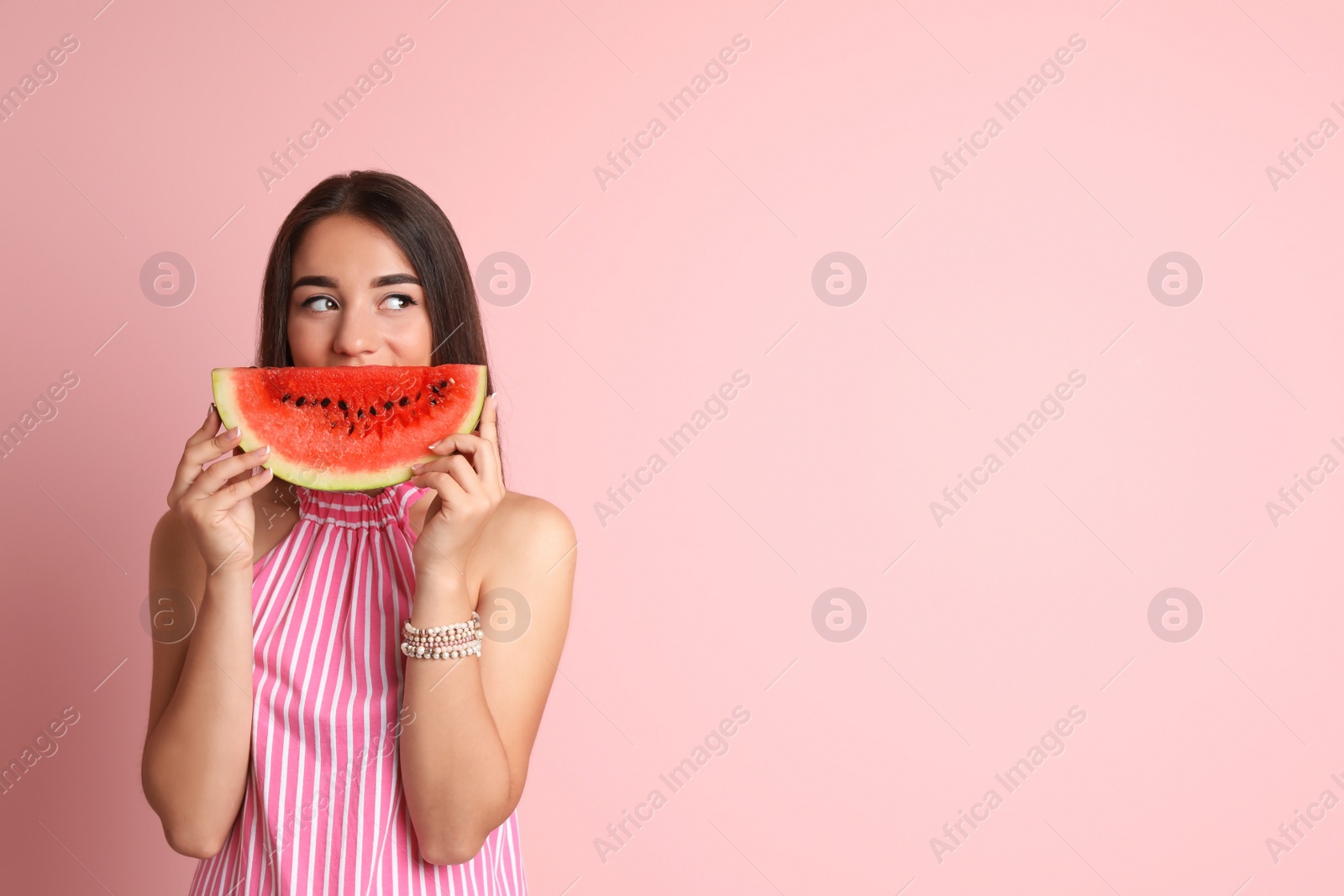 Photo of Beautiful young woman posing with watermelon on color background