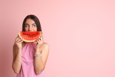 Beautiful young woman posing with watermelon on color background