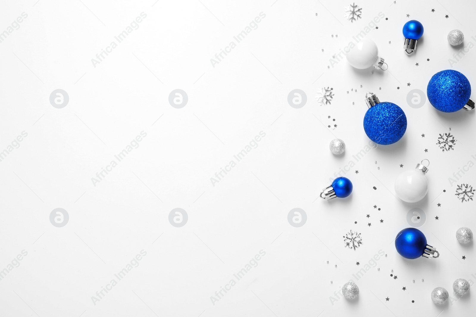 Photo of Colorful Christmas balls and sparkles on white background, top view