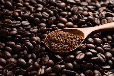 Spoon with instant coffee on roasted beans, closeup. Space for text