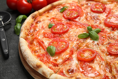 Delicious pizza Margherita and ingredients on dark grey table, closeup