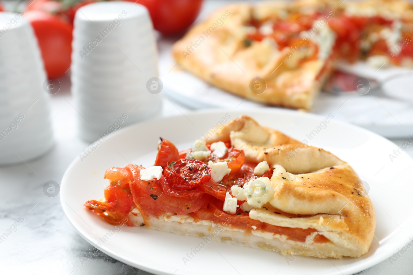 Photo of Tasty galette with tomato and cheese (Caprese galette) on white marble table, closeup