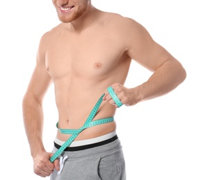 Young man with measuring tape showing his slim body on white background, closeup