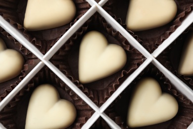 Photo of Tasty heart shaped chocolate candies in box, top view. Valentine's day celebration