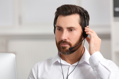 Photo of Hotline operator with headset working in office, space for text