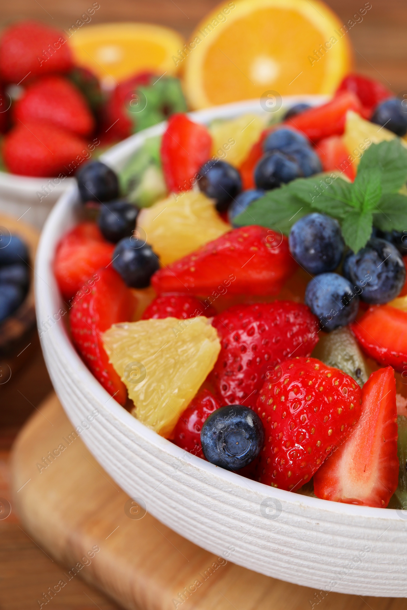 Photo of Delicious fresh fruit salad in bowl on table, closeup