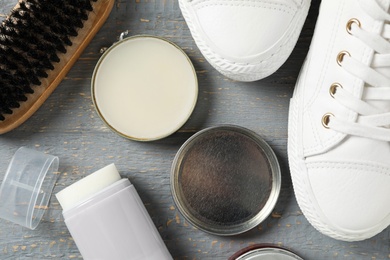 Photo of Flat lay composition with stylish footwear and shoe care accessories on grey wooden background