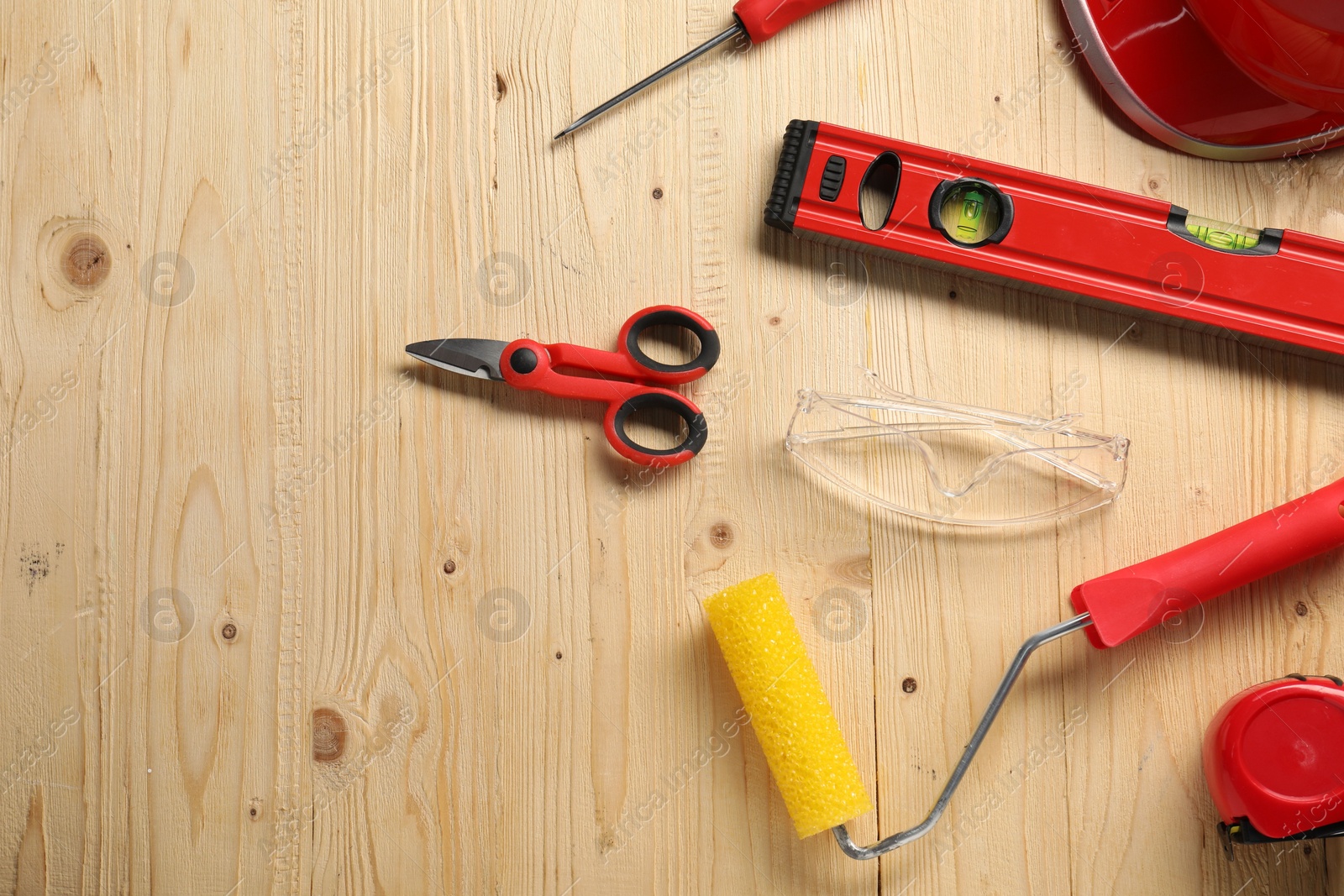 Photo of Flat lay composition with building level and other different construction tools on wooden background, space for text