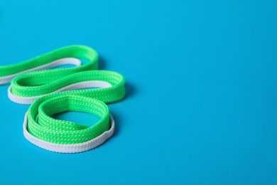 Photo of Mint and white shoe laces on light blue background. Space for text