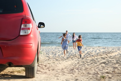 Photo of Little children running to their parents on sandy beach. Summer trip