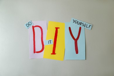 Photo of Phrase Do It Yourself and abbreviation DIY made of letters on light grey background, flat lay
