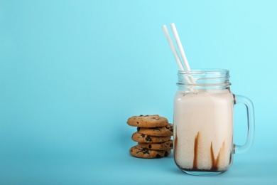 Photo of Mason jar with delicious milk shake on color background