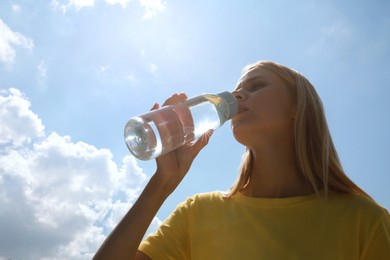 Woman drinking water to prevent heat stroke outdoors