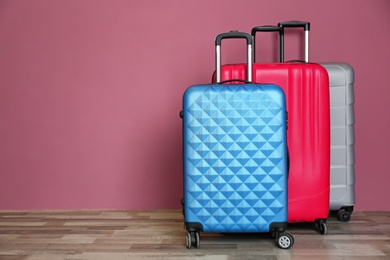 Different suitcases near color wall