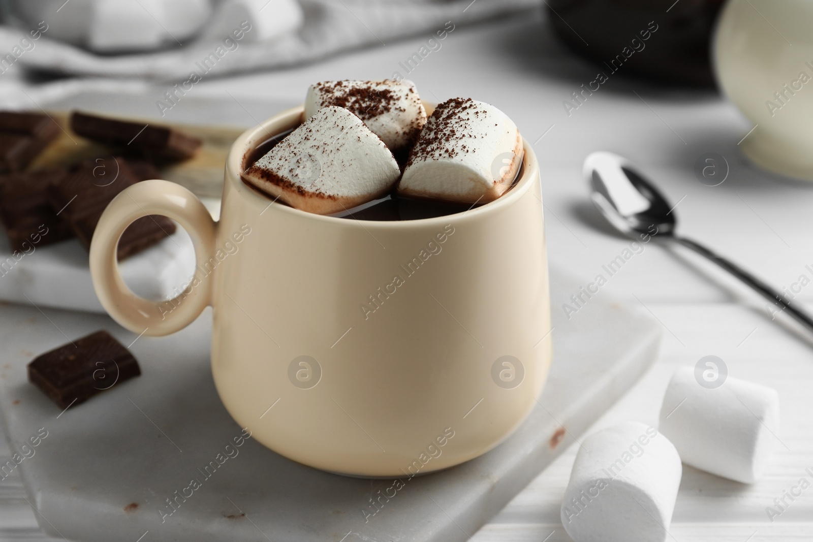 Photo of Cup of aromatic hot chocolate with marshmallows and cocoa powder on table, closeup