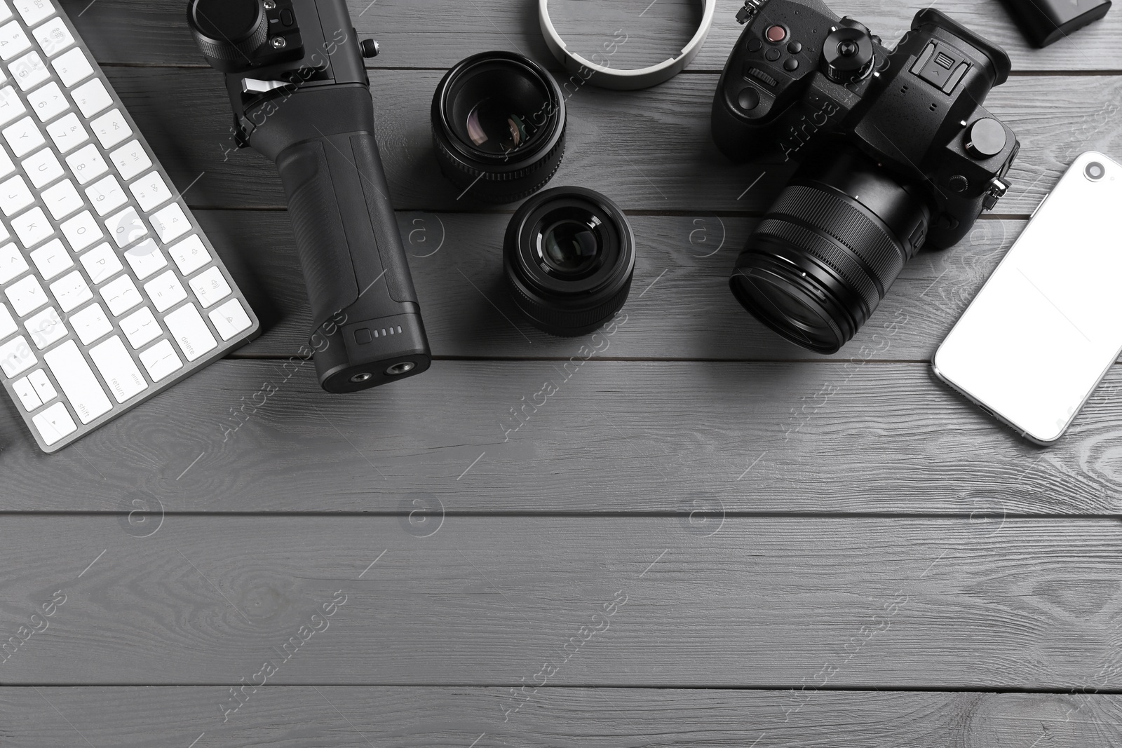 Photo of Flat lay composition with camera and video production equipment on grey wooden table. Space for text