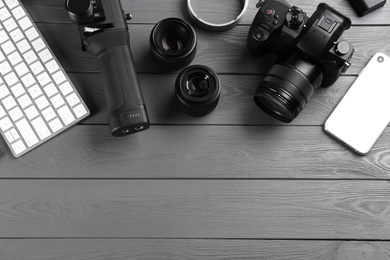 Photo of Flat lay composition with camera and video production equipment on grey wooden table. Space for text