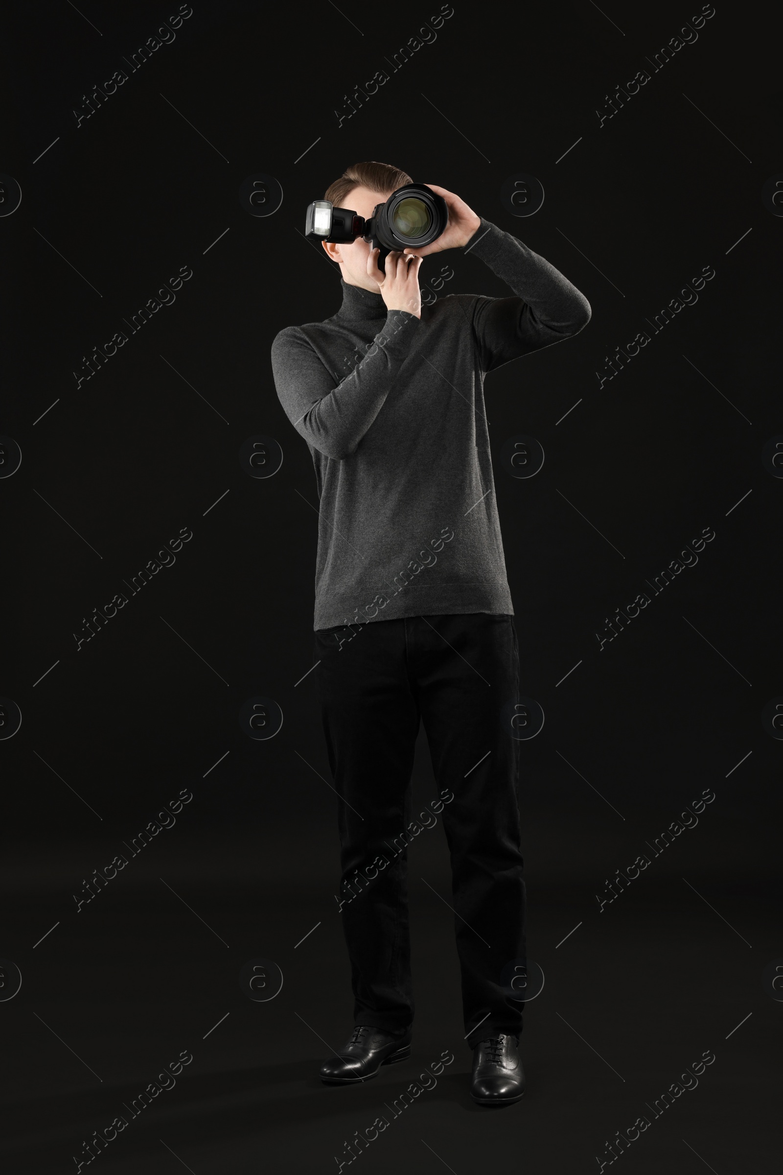 Photo of Professional photographer taking picture on black background