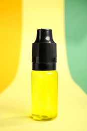 Photo of Bottle with yellow food coloring on bright background