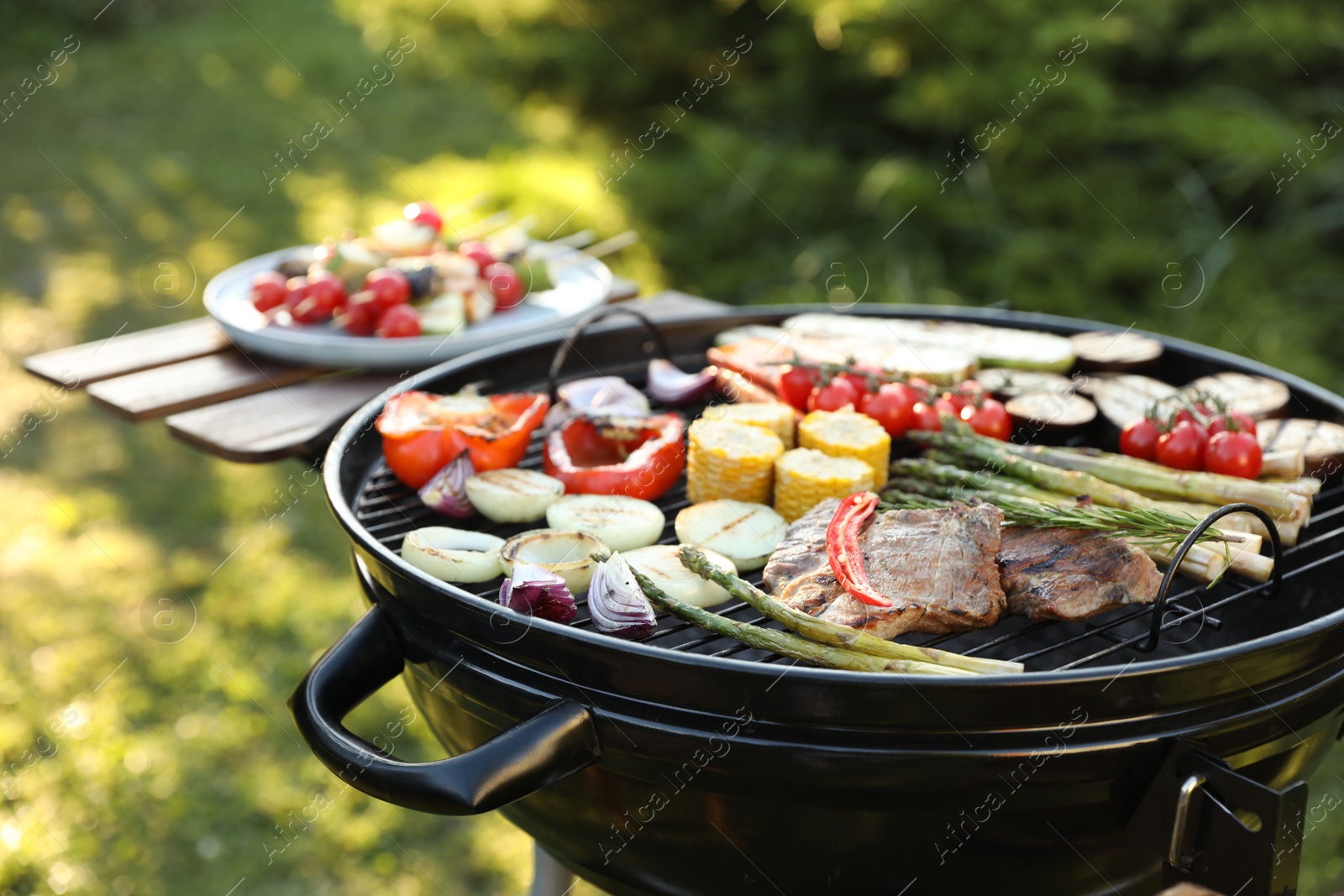 Photo of Delicious grilled vegetables and meat on barbecue grill outdoors, closeup