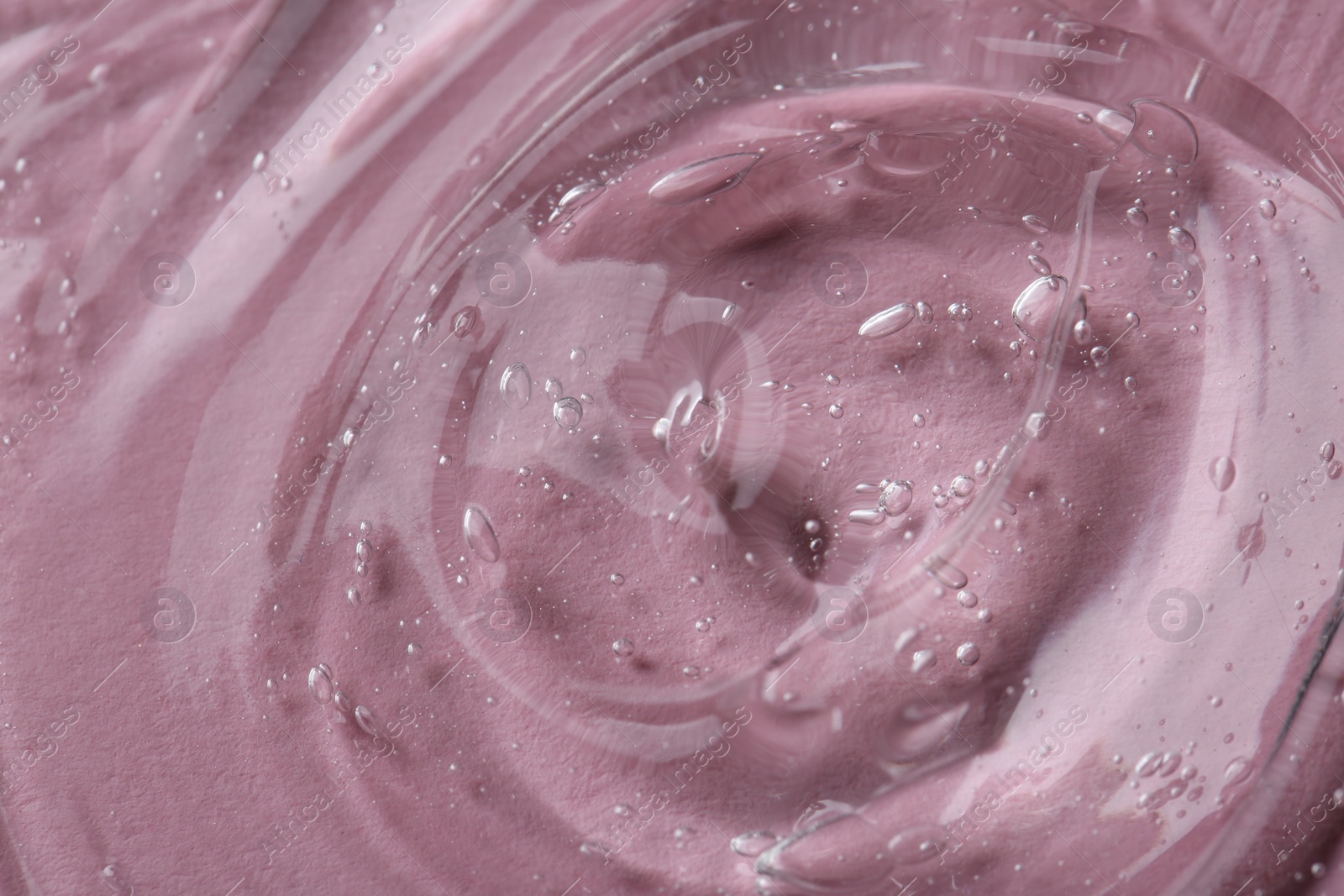 Photo of Clear cosmetic serum on pink background, macro view