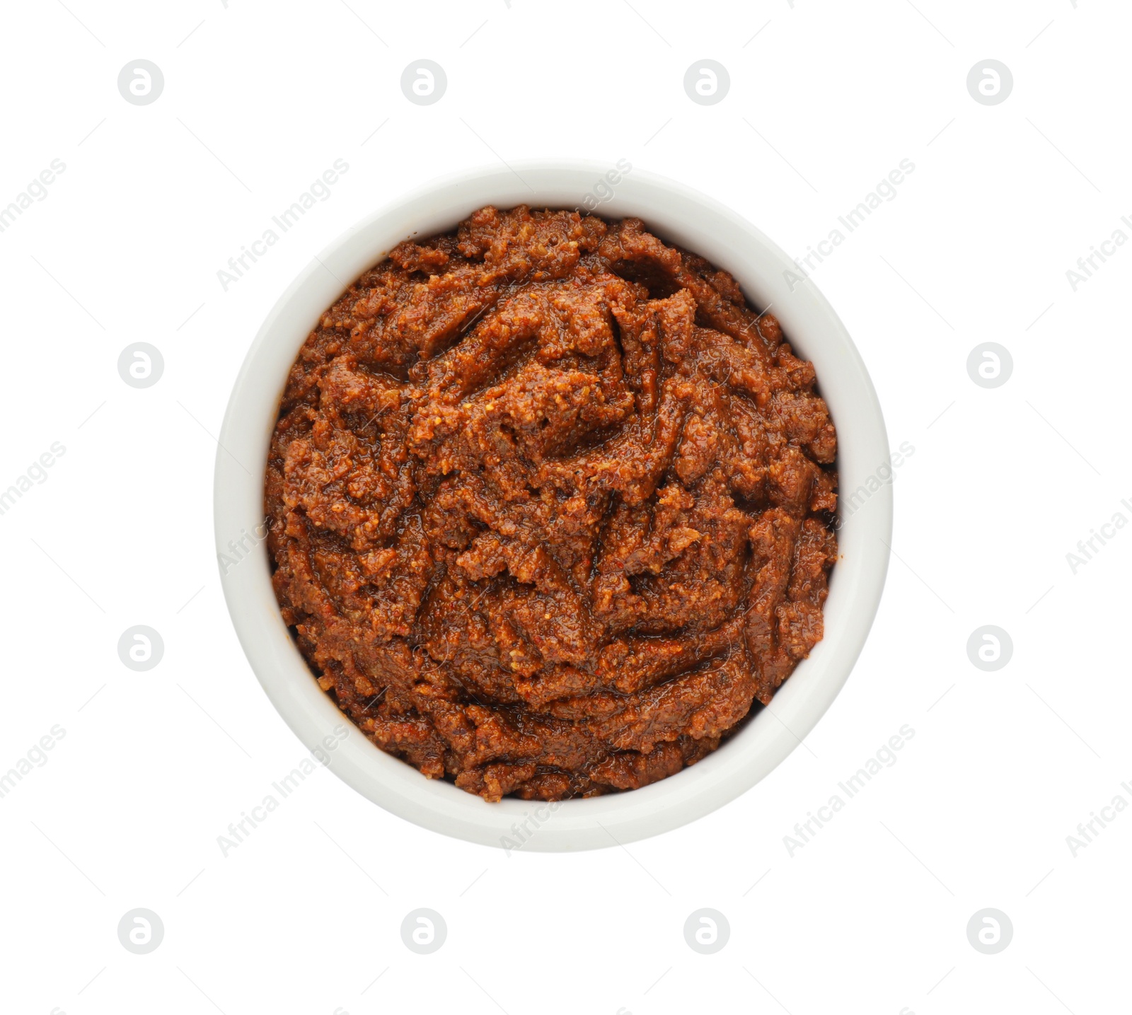 Photo of Delicious adjika sauce in bowl isolated on white, top view