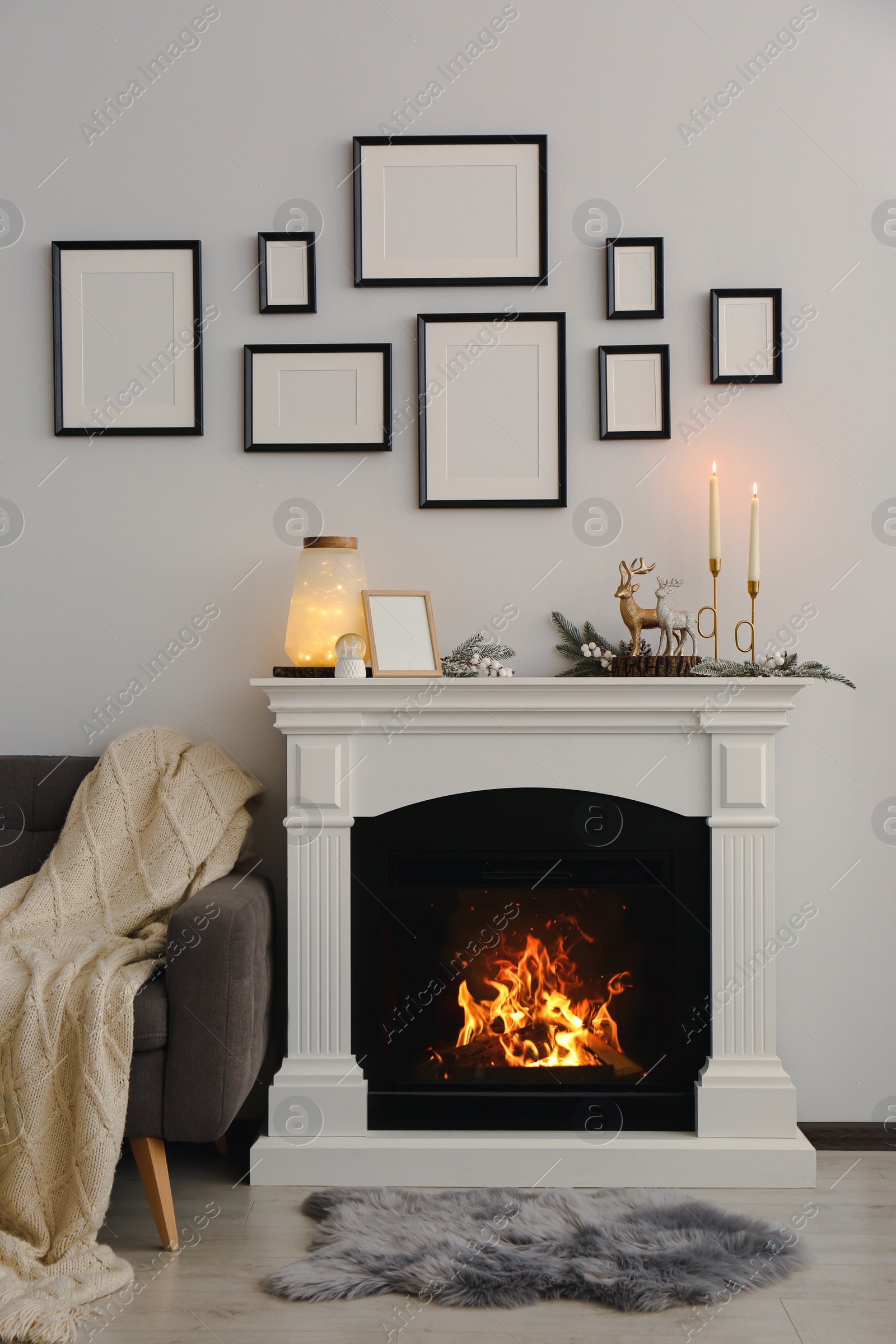 Photo of Stylish interior decorations on fireplace near white wall indoors