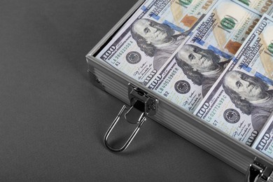 Photo of Briefcase with banknotes on grey table, closeup. Space for text